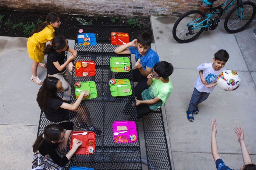 Students eat snacks and play soccer during a break.