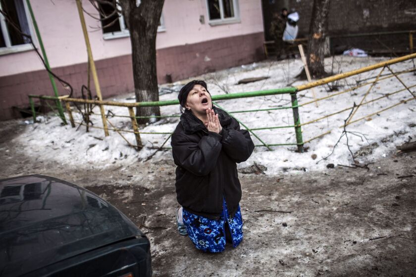 A Ukrainian woman begs Ukrainian President Petro Poroshenko to stop the bombing in Donetsk after shell hit the residential area where she lives, killing two civilians in Donetsk’s Kyibishevsky district, on January 29, 2015. MANU BRABO/AFP/Getty Images