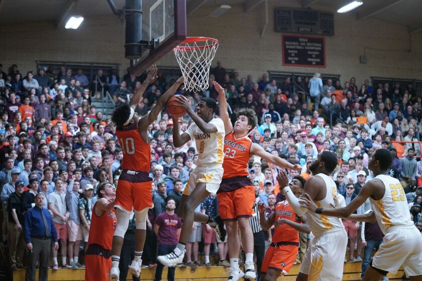 Simeon’s Antonio Reeves (3) slices between Brother Rice’s Jalen Rheams (10) and Anthony Arquilla (23).