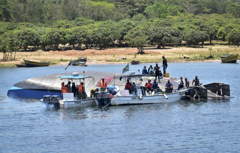 Rescue divers work alongside the capsized MV Nyerere passenger ferry on Ukara Island, Tanzania Saturday, Sept. 22, 2018. The death toll soared past 200 on Saturday while officials said a survivor was found inside the capsized ferry and search efforts were