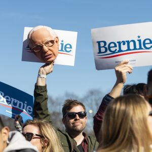 A Bernie Sanders supporter holds up a Bernie Sanders mask and sign, during the Bernie Sanders rally, Saturday, March 7, 2020.