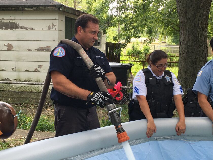 A Chicago firefighter helps fill up the pool quickly. | Maudlyne Ihejirika/Sun-Times