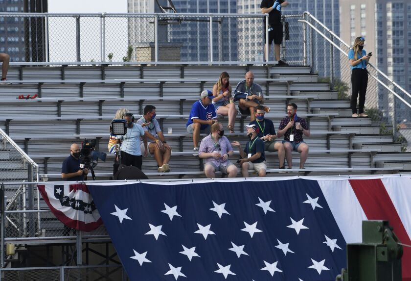Fans watch from the rooftops an opening day baseball game between the Chicago Cubs and the Milwaukee Brewers, Friday, July, 24, 2020, in Chicago.