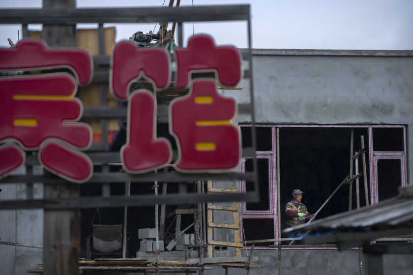 A construction worker labors at a hotel being built in a neighborhood of tourist homestays in Zhaxigang village near Nyingchi in western China’s Tibet Autonomous Region.