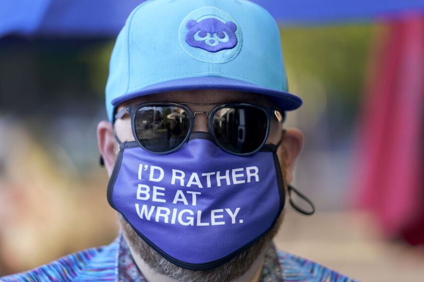 Patrick McCarron wears a Cubs cap and face mask as he heads to a rooftop bar for a game. The Cubs averaged 38,208 fans for their 81 home dates in 2019, trailing only the Los Angeles Dodgers, Cardinals and Yankees. Now, those crowds are gone.