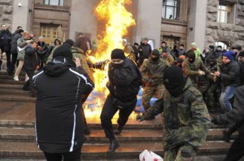Ukrainian protesters burn tires outside the city council building as they protest against raising the public transport rates in Kiev, Ukraine, Monday, Feb. 9, 2015. Public transport rates have doubled since last weekend. (AP Photo/Oleg Batrak)