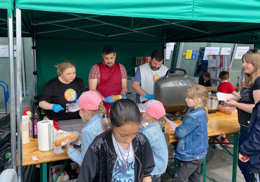 Olga Tsoi (left) helps distribute meals to refugees from Ukraine at a facility in Krakow, Poland.