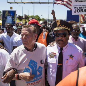 The Rev. Michael Pfleger and CPD Supt. Eddie Johnson march arm-in-arm. | Ashlee Rezin/Sun-Times