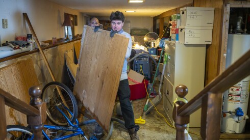 Workers with Restore Construction clean up and dispose of water-damaged belongings of Lorraine Runge’s Norwood Park home after a major storm rolled through the Chicago area Wednesday.