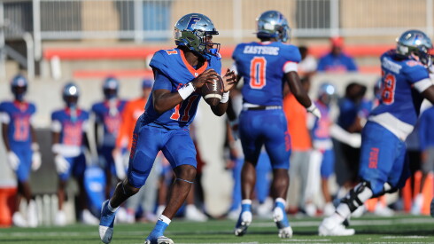 East St. Louis quarterback Reece Shanklin (11) rolls out to throw a pass against Mount Carmel.