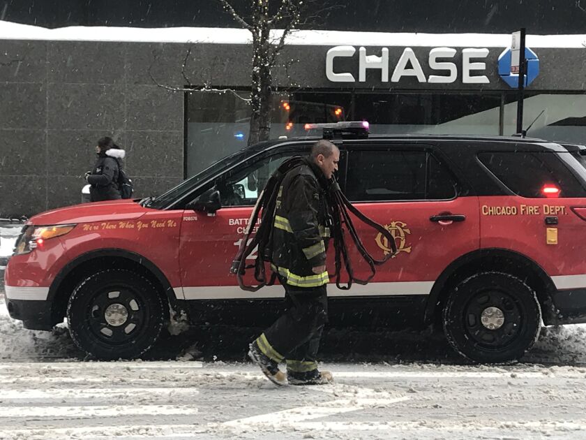 A firefighter responds to a car fire Sunday morning at a parking garage on the Magnificent Mile. | Tyler Lariviere/Sun-Times