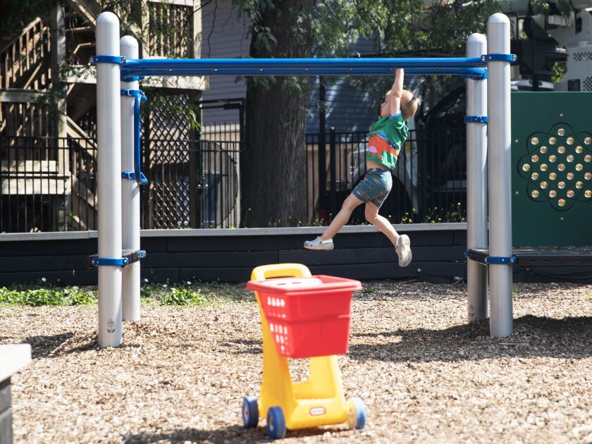 Elliot Goodman, 3, hangs from a set of monkey bars at Bixler Park.