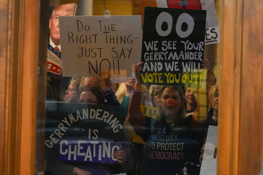 Protesters are seen through a window Thursday in the Senate Chamber during dissuasion before a vote to redistrict the state