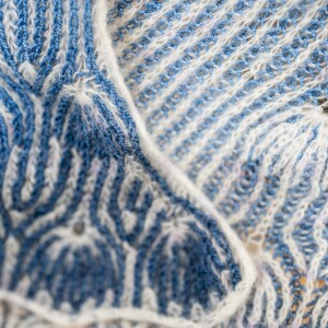 A blue and white knitted pattern called the Joyous Shawl pattern.