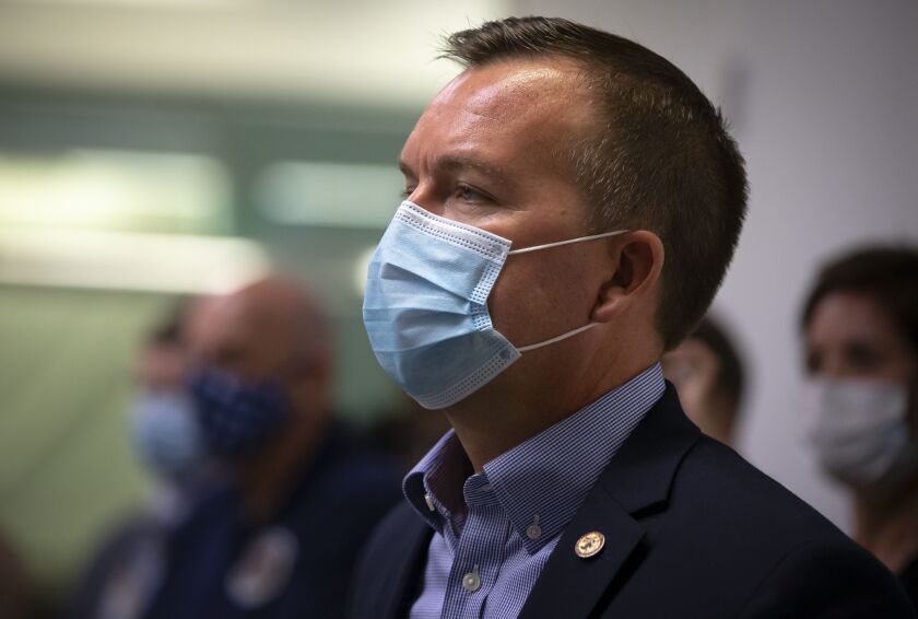 State Sen. Andy Manar, D-Bunker Hill, listens as Illinois Gov. J.B. Pritzker unveils a new mask awareness campaign in August.