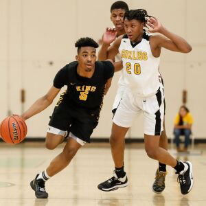King’s David Abdullah (5) takes the ball down the court past Corliss’ LeQuan Washington (20).