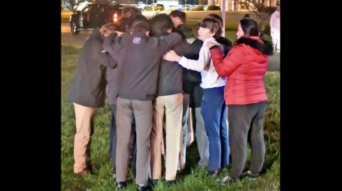 St. Ignatius junior varsity hockey players gather in prayer moments after a truck driver plowed into their bus in Indiana on Nov. 12, injuring 16 of them.