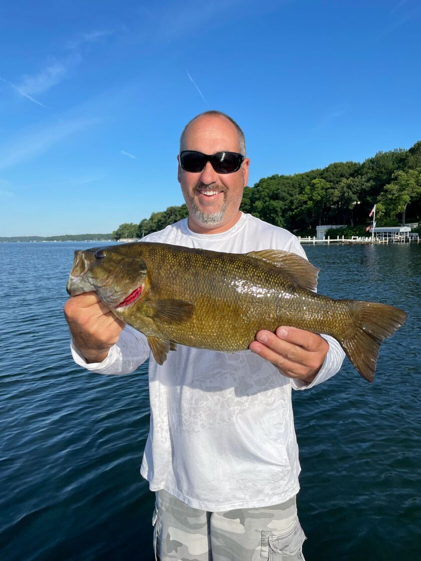Scott Heilman from Rockford holds a 21-inch smallmouth bass from Big Green Lake. Provided by Mike Norris