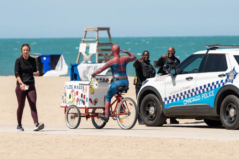 A man dressed as Spider Man salutes to police officers after a group of teenagers got into a fight and shots were fired, according to a Chicago Police Department spokesperson, ahead of Memorial Day weekend at North Avenue Beach, Friday, May 26, 2023. No one was injured and one individual is in custody, according to police. | Pat Nabong/Sun-Times