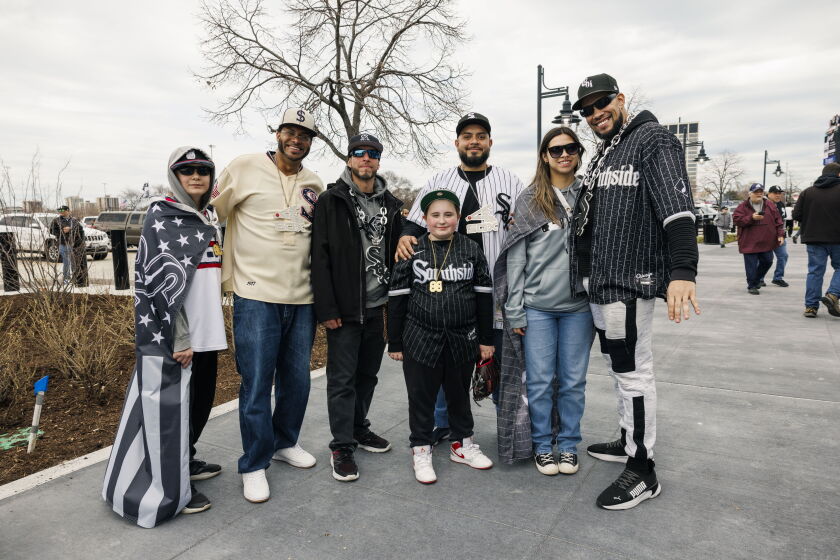 Fans dressed in White Sox apparel, necklaces and flags stand for a photo outside of Guaranteed Rate Stadium on the White Sox opening day, Monday, April 3, 2023.