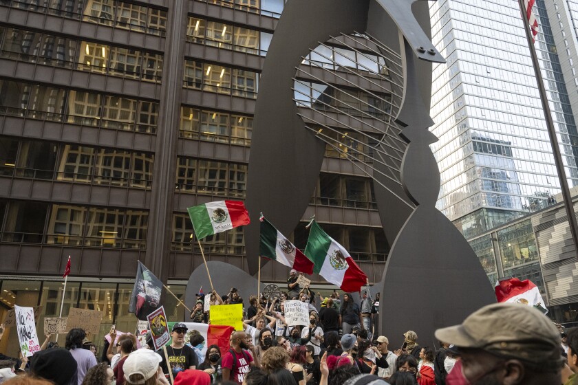 Demonstrators wave Mexican flags at Daley Plaza.