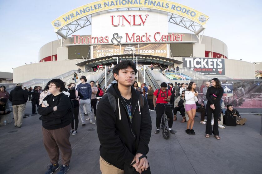 Oscar Hernandez, center, a University of Nevada, Las Vegas, student waits for a bus to take him off-campus after a fatal shooting.