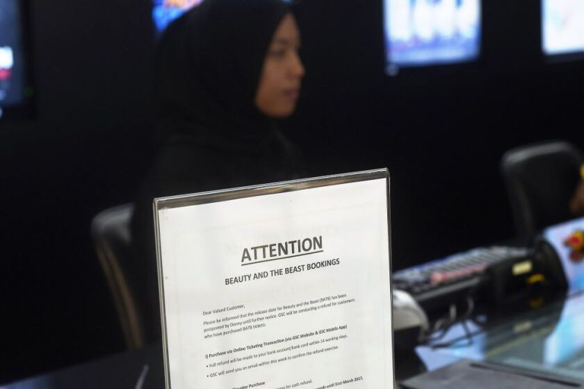 A Malaysian ticket-seller sits behind a notice displayed regarding the release of the film “Beauty and the Beast” at a Golden Screen Cinemas theatre in Kuala Lumpur on March 14, 2017.<br>Malaysian censors have reportedly cut out a “gay moment” in the Disn