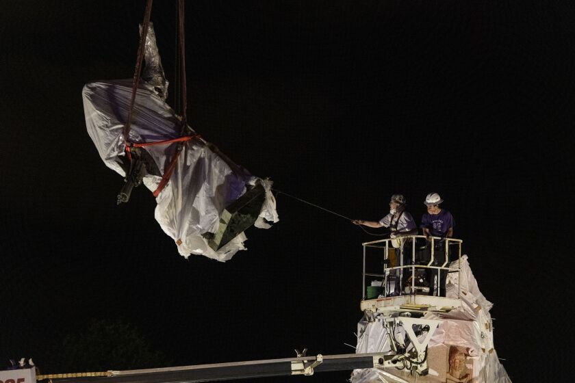 City crews remove the Christopher Columbus Statue in Grant Park about 3 a.m. Friday, July 24, 2020. The decision to remove the statue came after violent clashes between police and protesters broke out when activists tried but failed to take it down.