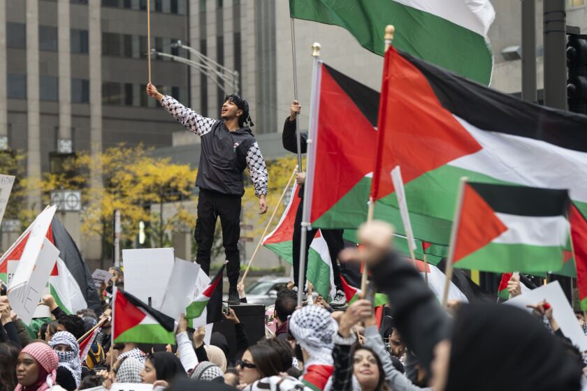 Palestinian supporters wave flags on Michigan Avenue during a rally in the Loop, where thousands of Palestinian supporters called for a ceasefire, an end to U.S. military aid to Israel and an end to Israeli occupation amid the Israel-Hamas war, Saturday, Oct. 21.