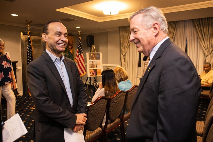 L'ex rappresentante degli Stati Uniti Luis Gutierrez saluta venerdì il senatore statunitense Dick Durbin all'Union League Club di Chicago.