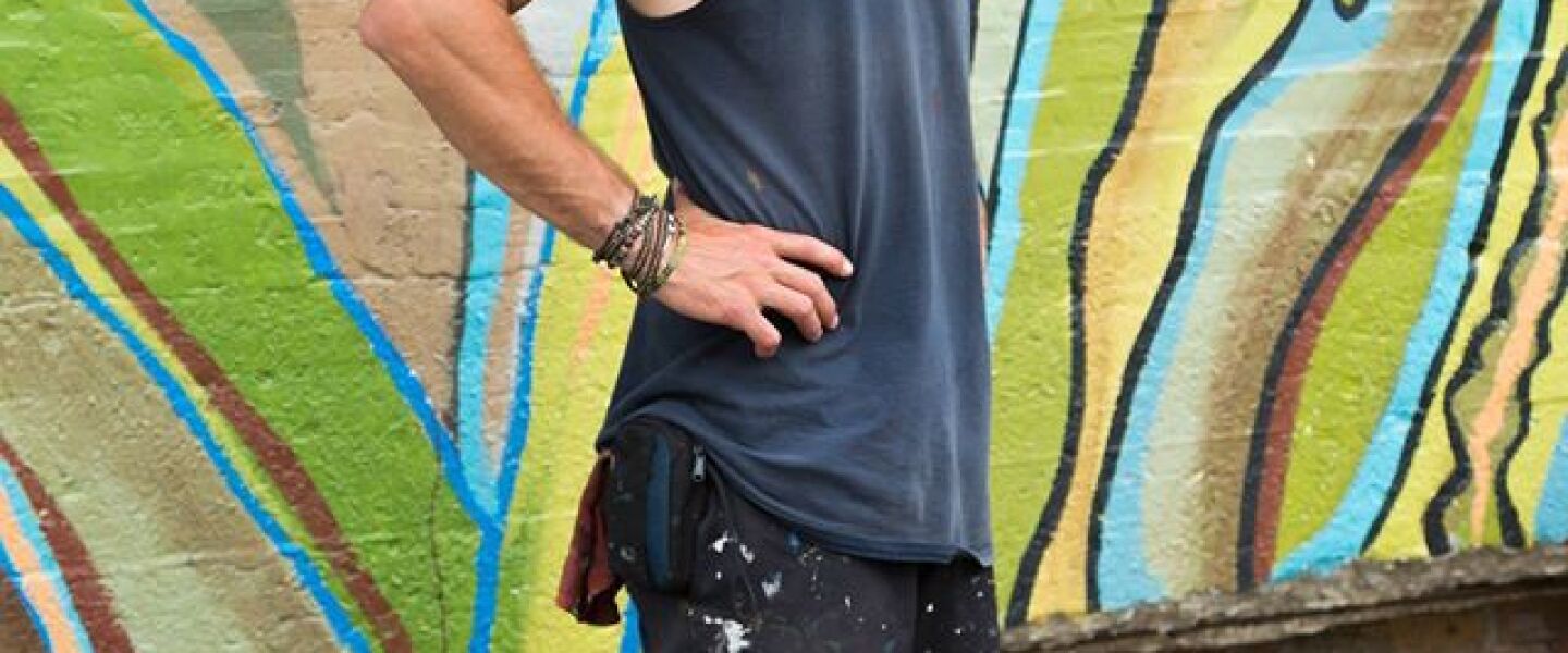 Chicago artist Joe Miller in warmer days at his mural at 1400 W. 46th St.