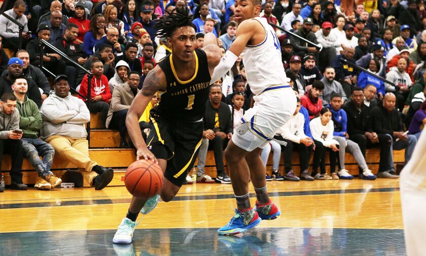 Marian Catholic’s Ahron Ulis (1) drives toward the basket as Bloom’s Dante Maddox Jr. (21) defends.