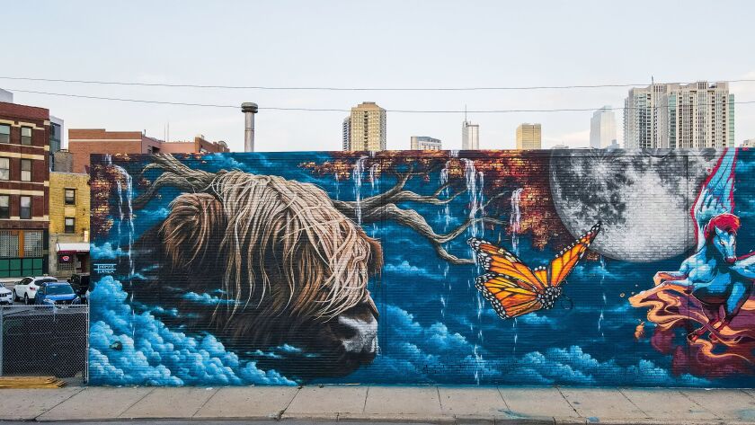 Thomas Turner’s side of the untitled mural uses his style of photo-realistic art to “create drama” and show wind in the long hair of a highland bull.