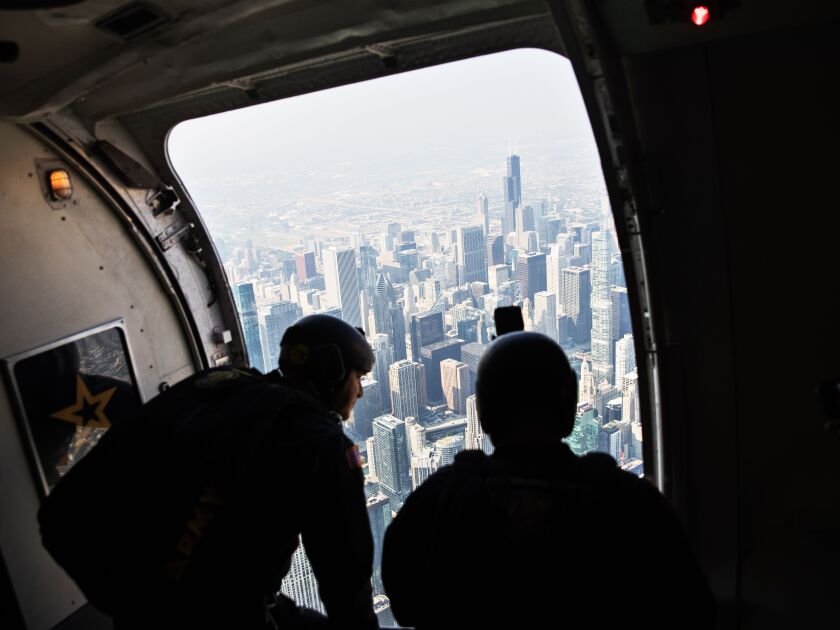 Members of the U.S. Army Golden Knights parachute team look down on the city from a C-147A plane before a practice jump Friday in preparation for the 2023 Chicago Air and Water Show.