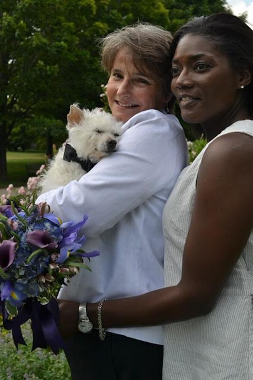 Nancy Lipman — holding Ben, one of her rescue dogs — with her wife Johanne M. Kenol.