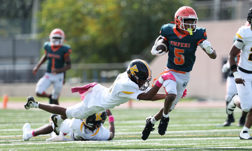 Morgan Park's Travezz Jones (5) drags a King defender for a few more yards before going down.