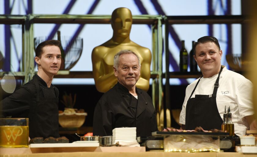Chef Wolfgang Puck (center) is flanked by his son Byron (left) and Eric Klein, vice president of culinary at Wolfgang Puck Catering, appear at the press preview for the 91st Academy Awards Governors Ball in Los Angeles in 2019. A new four-part documentary series, “The Event,” shows the intense planning and details that go into high-profile catering.