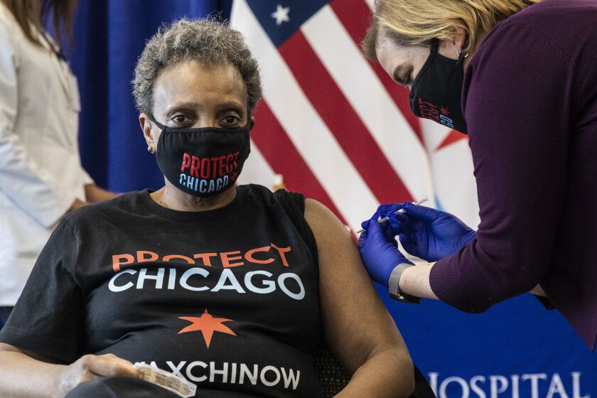 Dr. Allison Arwady, commissioner of the Chicago Department of Public Health, administers the first dose of the Pfizer-BioNTech COVID-19 vaccine to Mayor Lori Lightfoot last month at St. Bernard Hospital.