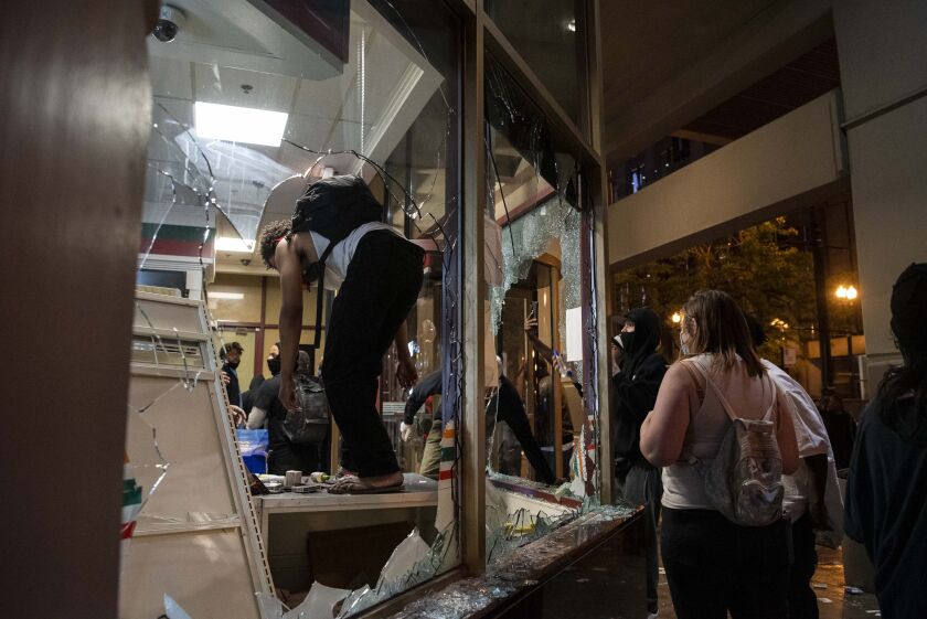 Protesters loot items from a 7/11 on Lake and Dearborn, during a protest for George Floyd, Saturday, May 30, 2020. 