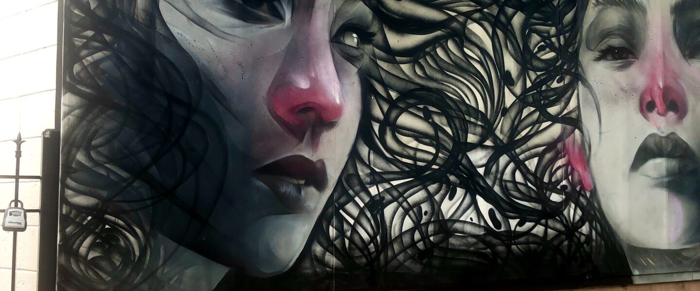 The artist rawooh describes Won Kim’s style in a Near West Side mural as being fluid with flat colors, which he tried to contrast through realistic portraits.