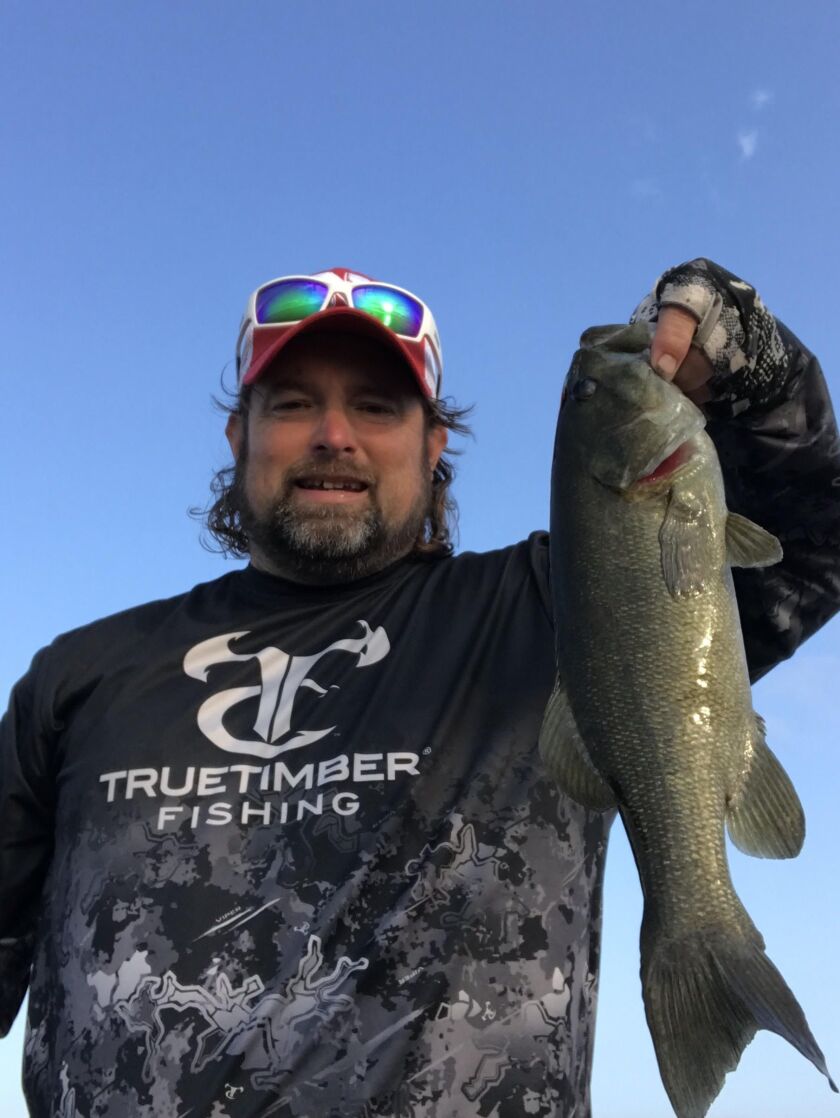 Ken “Husker” O’Malley holds a smallmouth bass from Heidecke Lake. Provided photo