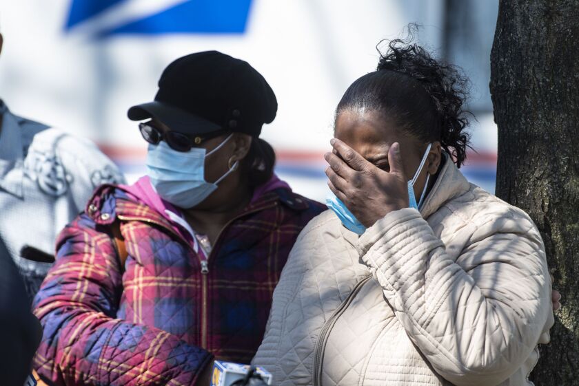 Members of Unique Clay’s family cry during a memorial service Saturday at Kilbourn Park.
