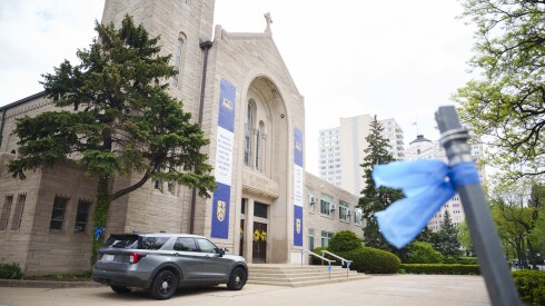 Blue ribbons are tied to a post outside St. Andrew’s Greek Orthodox Church in Edgewater, Wednesday, May 6, 2026, ahead of the visitation and funeral for police officer John Bartholomew, who was killed at Endeavor Health Swedish Hospital.