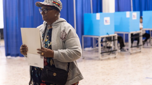 A voter prepares to turn in her completed ballot at the Dr. Martin Luther King Jr. Community Center in Bronzeville on Monday, Oct. 19,