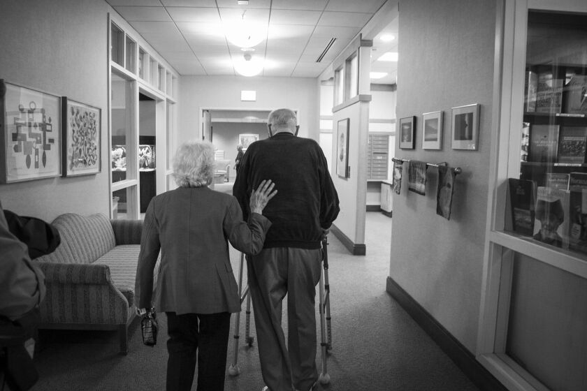 Evi Levin guides her husband Walter down a hallway at their home, Montgomery Place, in 2015. | Ashlee Rezin / Sun-Times