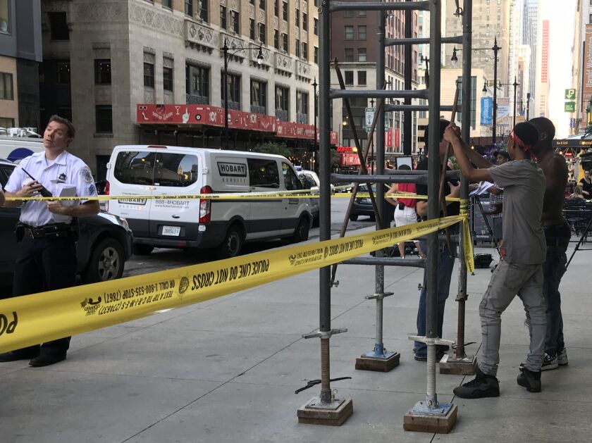 The brother and uncle of a teenage boy who was shot Friday wait near a crime scene in the Loop. | Matthew Hendrickson/Sun-Times