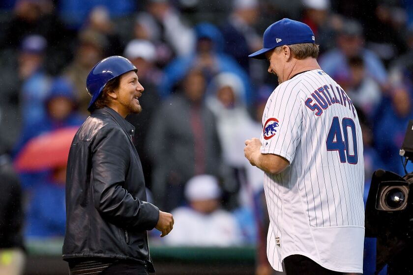 <em>Eddie Vedder and Rick Sutcliffe meet for a ceremonial first pitch. “The Baron” chucked it (up and in), and the Pearl Jammer caught it. (Getty Images)</em>