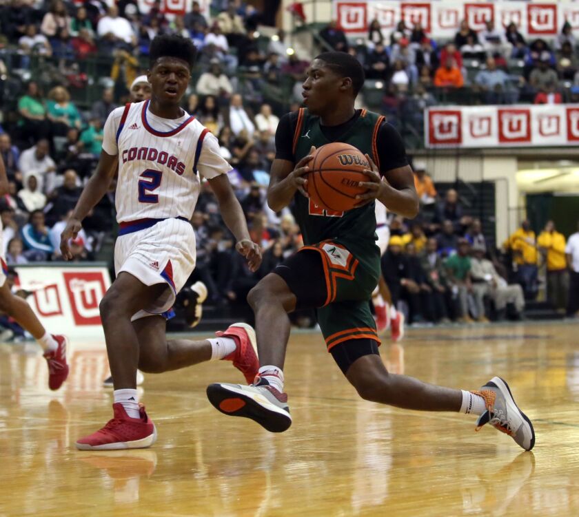 Morgan Park’s Marcus Watson (22) drives around Curie’s Damari Nixon (2) during the Public Leguat title game at CSU in February.