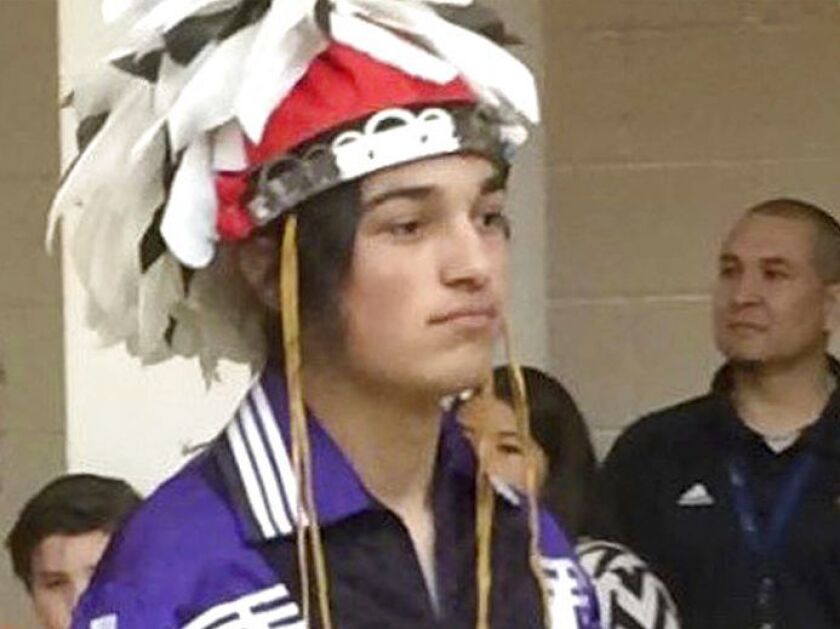 In this May 26, 2016 photo provided by the Gray family, Thomas Kanewakeron Gray walks in a procession during his high school graduation at Santa Fe Indian School in Santa Fe, New Mexico. Gray and his brother Lloyd Skanahwati Gray, were pulled from a Color