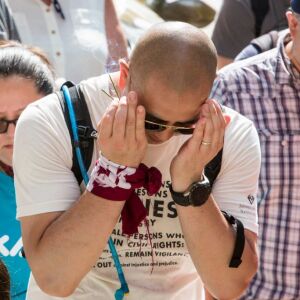 Brian Ozaki prays with a consortium of Asian American groups brought together by the Japanese American Service Community to participate in the Families Belong Together march starting in Daley Plaza, Saturday, June 30th, 2018. | James Foster/For the Sun-T